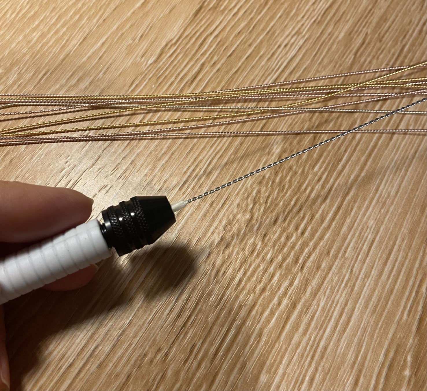 Pin vise alongside miniature drill bits for scale